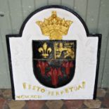A plaster armorial arched plaque with raised relief detail and painted finish, 77 cm wide x 84 cm