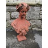 A composition stone bust in the form of an art nouveau maiden with flowers in her hair and