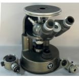 An inverted Microscope, circa 1960’s made by C. Baker Ltd, with spare lenses and with it’s wooden