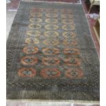 A Large Princess Bokhara Design Rug in faded burnt orange tones with an intricate dark blue