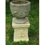 A weathered cast composition stone circular garden urn, with repeating Greek key fixed ring and
