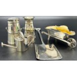 A collection of miniature silver garden items consisting of a shovel, watering can, wheelbarrow,