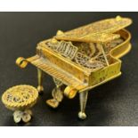 A miniature filigree wirework silver gilt grand piano with a hinged lid and together with its