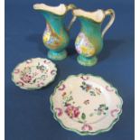 A pair of early 19th century ewers with turquoise glaze and hand painted floral reserves with