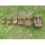 six old weathered cast iron Avery weights, 56lbs, 28lbs, 14lb, and three 7lbs examples