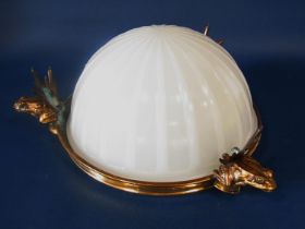 An opaque white glass ceiling light, a segmented glass bowl resting in a brass circular frame,