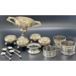 Four assorted silver napkin rings, four small silver salt bowls, four salt spoons and a silver