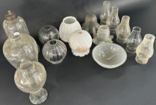 A large selection of Victorian oil lamps, glass fruits and shades, and other types of glass light