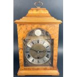 A walnut bracket clock in the Georgian style, the broken brass arched dial with cherub spandrels and