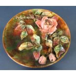 A majolica wall plate with rose and vine pattern together with a cut glass vase and a Carlisleware