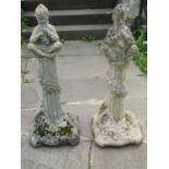 Two weathered cast composition stone garden ornaments in the form of 'Pan' seated cross legged on