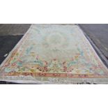 A European style Chinese rug with scrolling floral design, in pale tones on an ivory ground, approx.