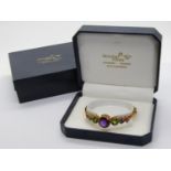 18ct multi gem hinged bangle by Nicholas Wylde, bezel set with graduated amethyst, peridot and