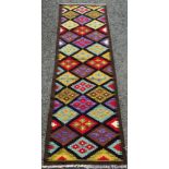 A Maimana Kilim runner with all over multicoloured stepped diamonds on a black field, 204 x 62cm