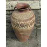 A terracotta oviform storage jar with repeating incised detail, 72cm high