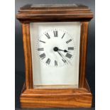 A small 19th century mantle clock with eight day time piece within a polished walnut case - with key