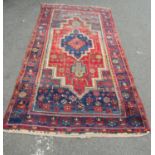 A Middle-Eastern design rug with elongated stepped medallion with stylised flowers, in various