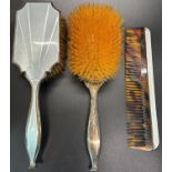 An Art Deco enamelled mirror and brush set with a single comb, a scrolled silver handled mirror, two