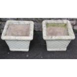 A pair of painted and weathered cast composition stone lattice basket planters of square tapered