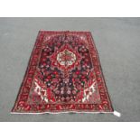 A North-west Persian Sarouk Rug, with an overall floral design predominantly in blue and red with