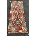 A Chobi Kilim runner with four multicoloured stepped medallions the centre 189 x 67cm approx.