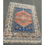 An old Kazak rug with central hexagonal stepped medallion and repeated geometric borders, in tones