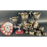 A collection of silver plated Rose Hill School trophies on stands one with a silver winners band.