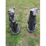 A pair of painted and weathered cast composition stone garden ornament in the form of seated cats,