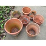 A small collection of weathered terracotta flower pots of varying size and design including a few