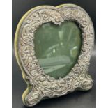 A silver heart shaped photo frame embossed with garlands of flowers, 16cm x 14cm, Birmingham 1998,