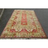 A Kazak style rug with central geometric panel, in orange and natural wool tones, 315 x 197 cm