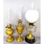 Two brass Victorian oil lamps with glass chimney's and a brass oil lamp with a spread foot, glass