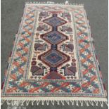 A Kazak rug with triple medallion and stylised birds in traditional tones approx. 196 x 130 cm