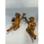 A pair of carved oak cherubs both with damage to limbs and hands, etc, 17cm high.