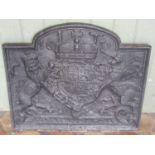 An old heavy cast iron fire back with armorial shield, lion, unicorn and coronet detail and dated