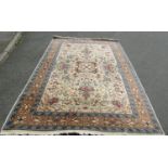 A Persian Isfahan style rug with rose, urn and bird motifs in cream, blue and orange, approx. 300