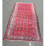 A Persian rug with multiple rows of stylised animals in red, pink and brown tones, 280 x 138 cm