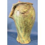 An art nouveau studio pottery vase with verdigris effect finish in the form of a reclining female
