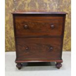 A Georgian mahogany commode with rising lid, the front elevation presented as two drawers on bun