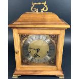 A walnut cased bracket clock in the Georgian style retailed by Dent of London, the square brass dial