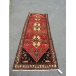 A North-west Persian Heriz Runner, with tribal design in tones of umber, ochre and brown/madder, 280