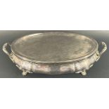 A silver plated oval twin handled heating tureen with removable platter, lacks burner, raised on