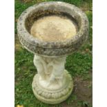 A weathered cast composition stone two sectional bird bath, the circular top with repeating leaf