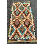A Chobi Kilim runner with a multi coloured repeating geometric pattern 153 x 65cm approx.