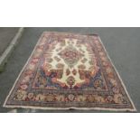 A Persian traditional design rug with floral motifs in various tones on a central cream ground,