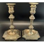 A pair of 19th century silver candlesticks with a waisted faceted stem and spread foot, 18cm high,