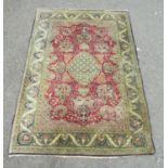A Persian hand-knotted wool rug with vases of flowers and a scrolling floral border, in tones of