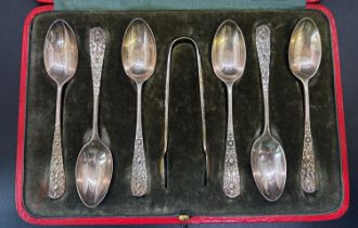 A cased set of six Harrods silver teaspoons with a sugar tong, hallmarked Harrods London, 1908, in