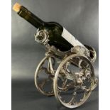 An early 20th century silver plated wine bottle carriage, with adjustable elevation mechanism, on