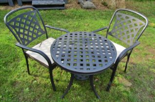 A contemporary coated cast alloy three piece garden terrace set with lattice detail, the table